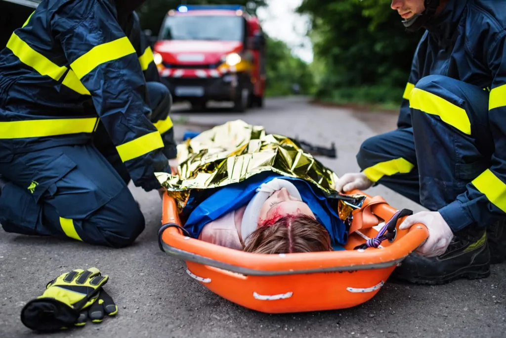 Erste Hilfe Kurse für Feuerwehren - zwei Feuerwehrleute verarzten eine verletzte Dame.